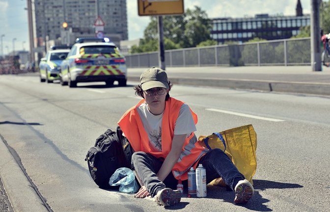 Aktivistin am Samstag auf der Konrad-Adenauer-Brücke in Mannheim – kurz bevor sie mit Öl übergossen wird.<span class='image-autor'>Foto: Letzte Generation</span>