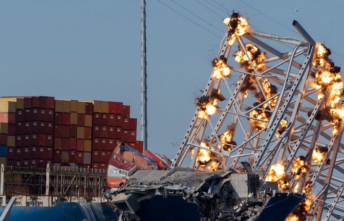 Eine kontrollierte Sprengladungen soll Teile der eingestürzten Francis Scott Key Bridge, die auf dem Containerschiff Dali liegt, in Baltimore zum Einsturz zu bringen.<span class='image-autor'>Foto: Mark Schiefelbein/AP/dpa</span>