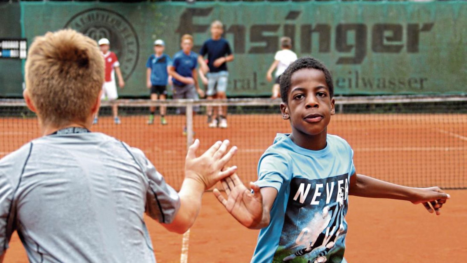 Abklatschen beim Staffellauf – die 30 Teilnehmer am Tenniscamp des TSC Vaihingen wärmen sich morgens mit Liniensprints auf.  Foto: Küppers