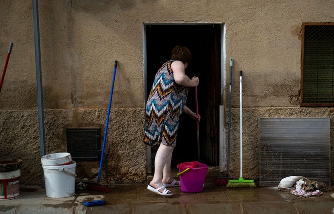 Eine Frau reinigt im spanischen Tarragona den Boden vor ihrem Haus. Wegen der schweren Unwetter in weiten Teilen des Landes durften knapp 10.000 Menschen am Sonntag ihre Häuser und Wohnungen nicht verlassen.<span class='image-autor'>Foto: Lorena Sopêna/EUROPA PRESS/dpa</span>