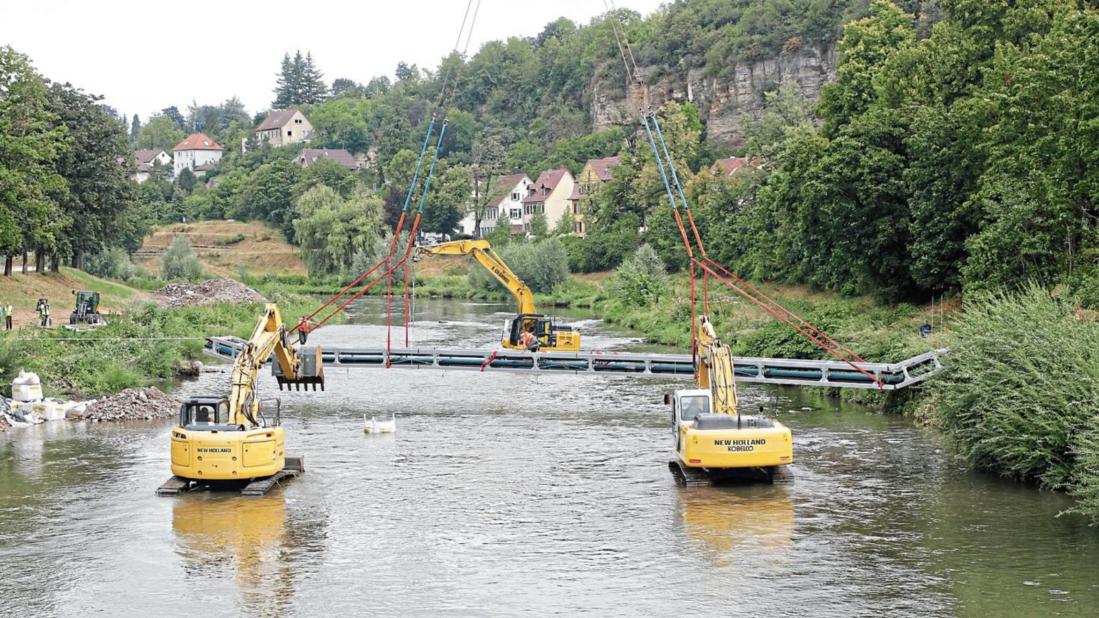 Das könnte die Premiere eines „Synchron-Baggerns“ gewesen sein: Die drei Baumaschinen transportierten die Konstruktion von der Dürrmenzer Enzseite zur anderen. Fotos: Kollros Das könnte die Premiere eines „Synchron-Baggerns“ gewesen sein: Die drei Baumaschinen transportierten die Konstruktion von der Dürrmenzer Enzseite zur anderen. Fotos: Kollros