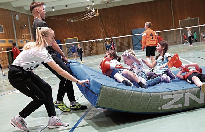 Fröhliche Kinder, fröhliche Betreuer: Wenn Lena und Jan Schiller die Matten zurückziehen, nutzen einige Kinder aus der TVV-Ballschule dies als Mitfahrgelegenheit. Fotos: Küppers