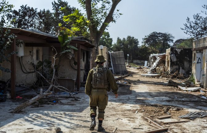 Ein israelischer Soldat geht an zerstörten Häusern im Kibbuz Kfar Aza vorbei. Der Kibbuz war im Oktober 2023 von Hamas-Terroristen angegriffen worden. Viele Bewohner wurden ermordet.<span class='image-autor'>Foto: dpa/Ilia Yefimovich</span>