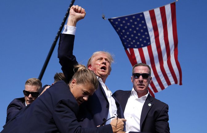 Ein Bild, das Geschichte schreiben wird: Donald Trump streckt kurz nach dem Schuss blutend die Faust gen Himmel.<span class='image-autor'>Foto: dpa/Evan Vucci</span>