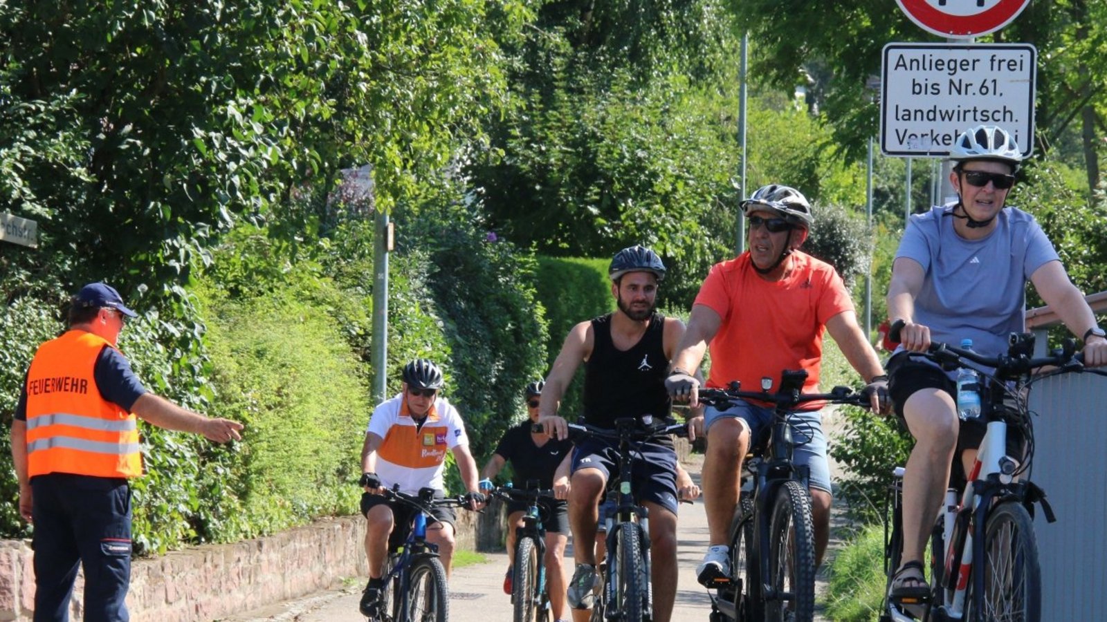 Ein Feuerwehrmann dirigiert die Radler bei Sachsenheim auf den Gehweg.
