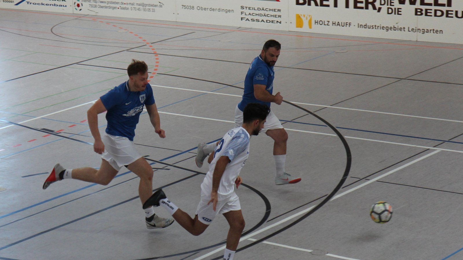 Die beiden Vaihinger Daniel Beck (links, blau) und Qendrim Emini (rechts, blau) verfolgen einen Flehinger Spieler.   Foto: Dittrich