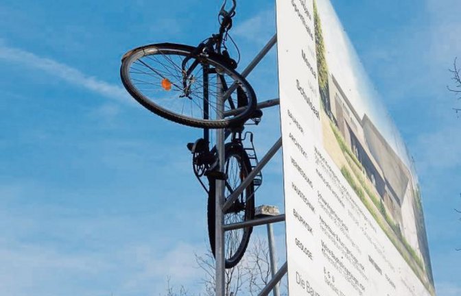 Zweifelhafter Scherz: Fahrrad in luftiger Höhe an der Bautafel der Halle bei der Vaihinger