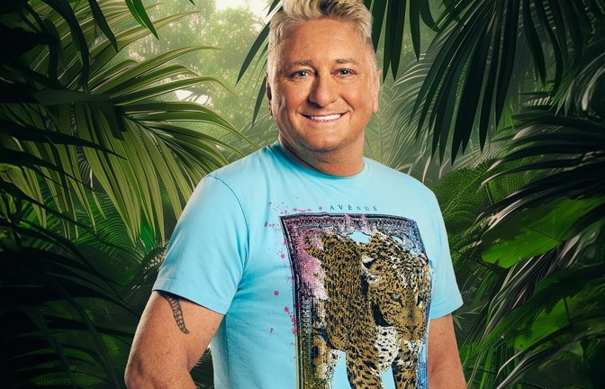 Hubert Fella kämpft im „Dschungelcamp“ von RTL um die Dschungelkrone.<span class='image-autor'>Foto: RTL / Hintergrund KI-generiert</span>