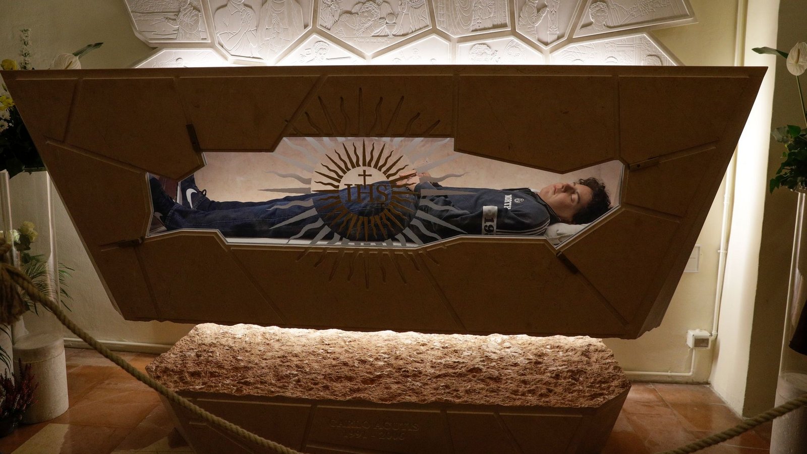 Der Leichnam von Carlo Acutis liegt in einem Sarkopharg, in den man hineinsehen kann. (Archivbild)Foto: Gregorio Borgia/AP/dpa