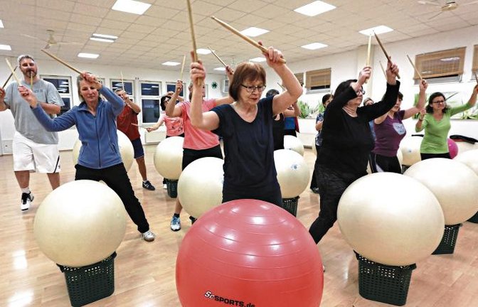 Trommeln auf den Ball, dann die Stöcke in die Höhe – Drums Alive macht fit. Foto: Küppers