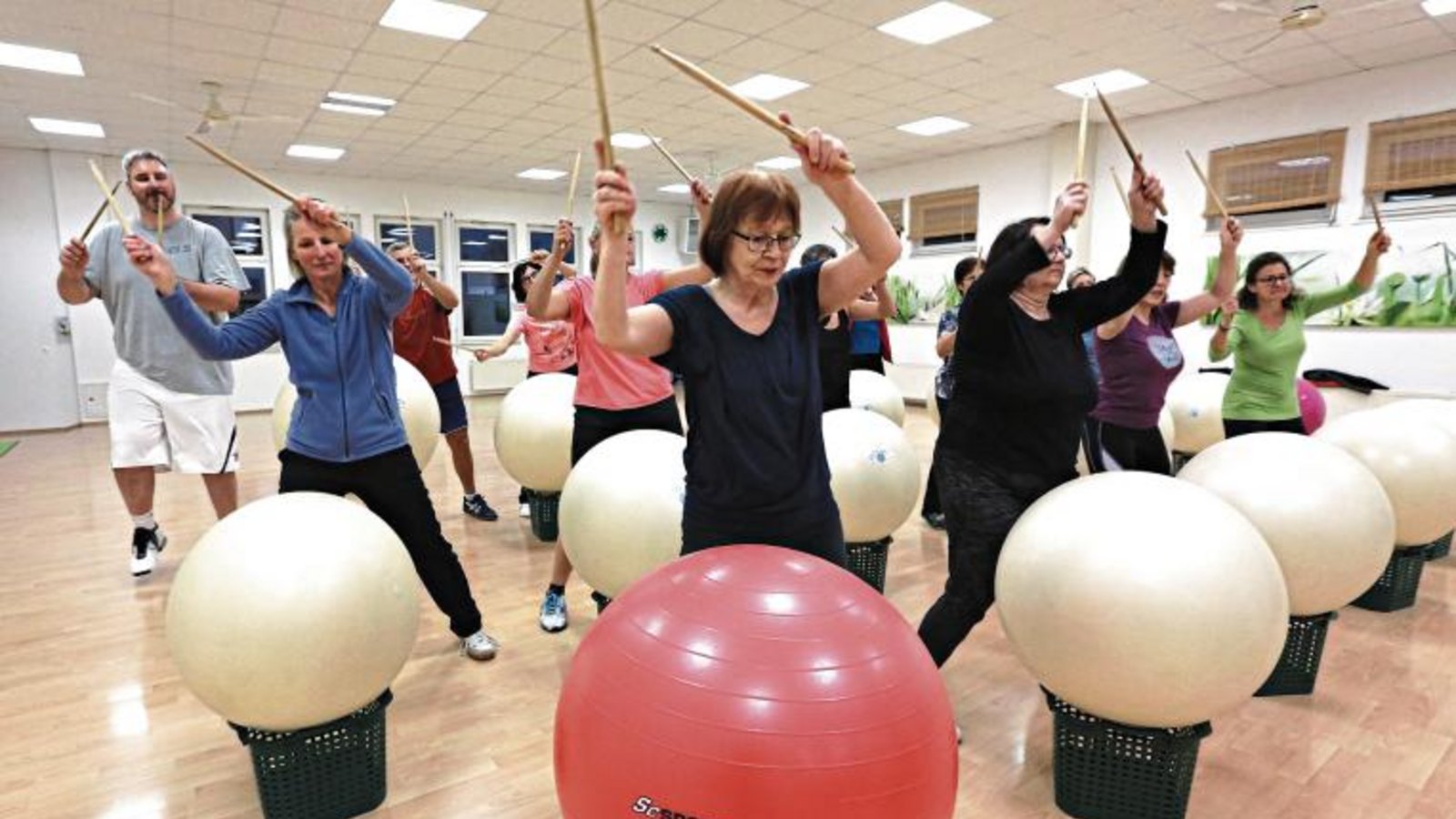 Trommeln auf den Ball, dann die Stöcke in die Höhe – Drums Alive macht fit. Foto: Küppers Trommeln auf den Ball, dann die Stöcke in die Höhe – Drums Alive macht fit. Foto: Küppers