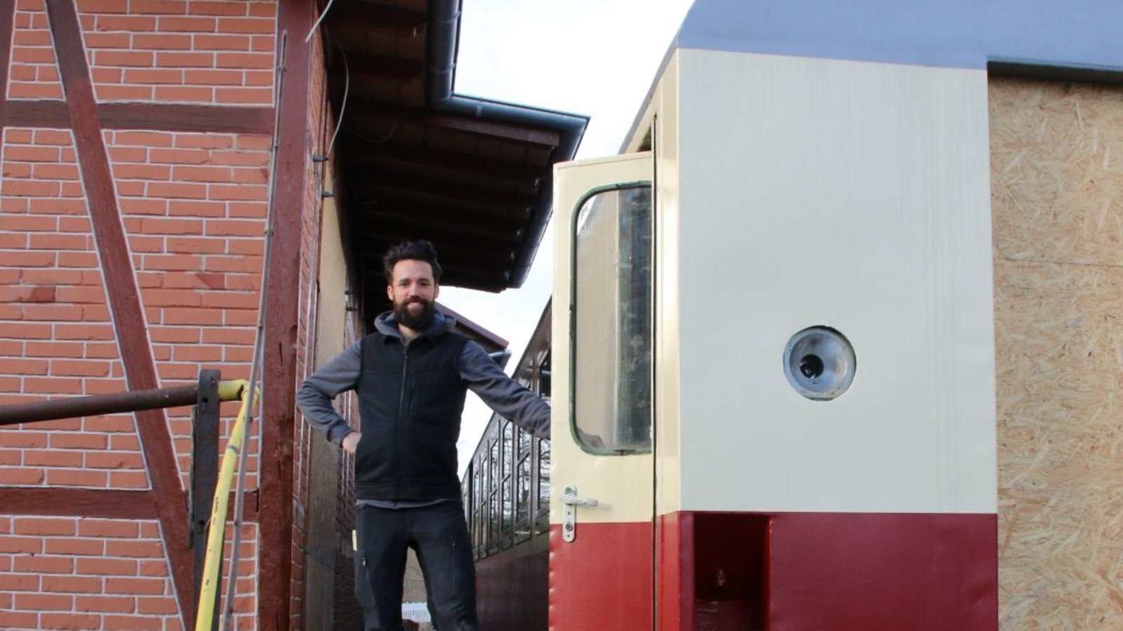 Benjamin Geier zwischen Bahnhof und dem Reisezugwaggon, der bewirtschaftet wird. Benjamin Geier zwischen Bahnhof und dem Reisezugwaggon, der bewirtschaftet wird.