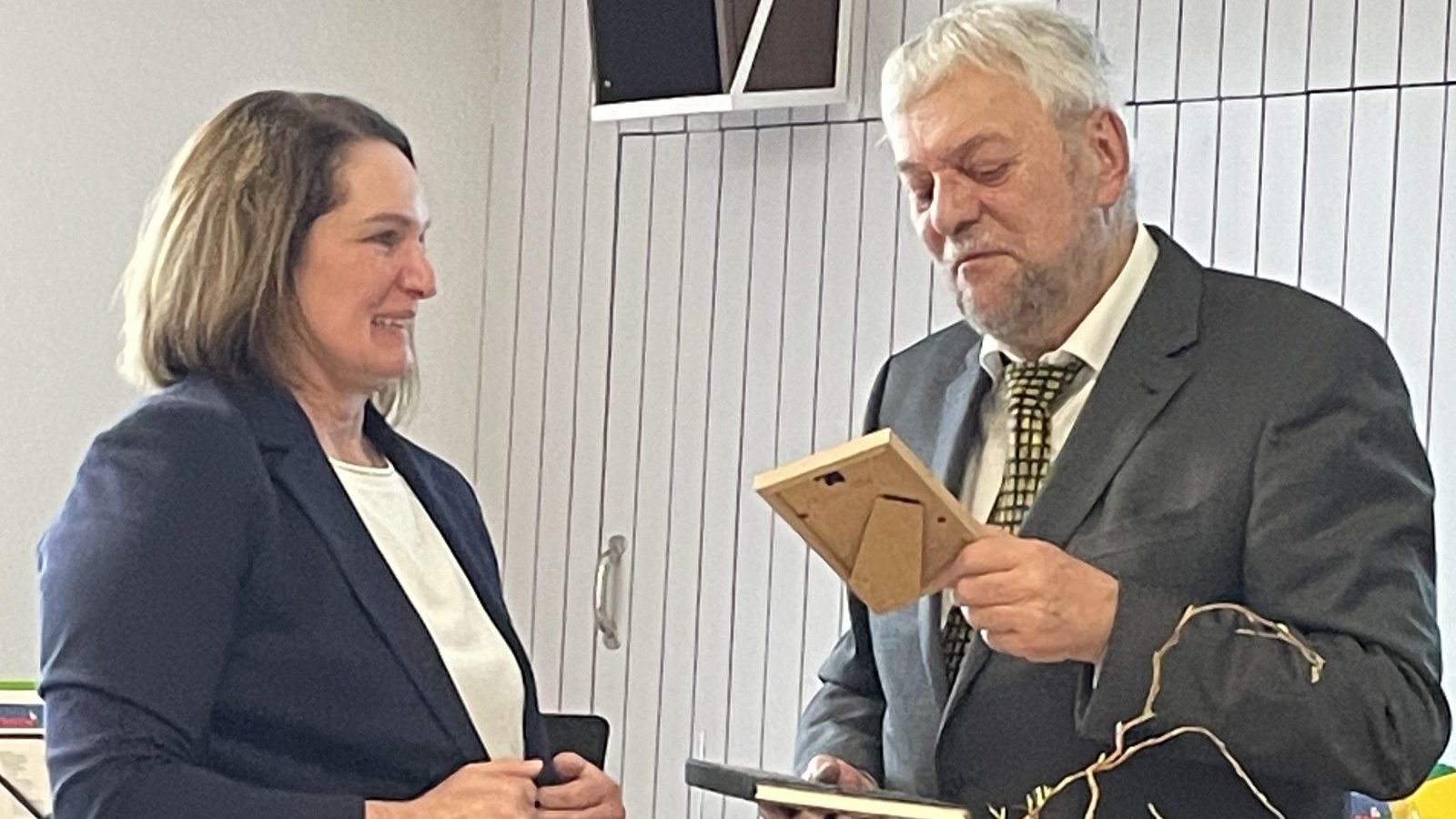 Claus Flaith übergibt Katja Kraft einen eingerahmten Zettel, der an ihre erste Begegnung erinnern soll.  Foto: Stogios