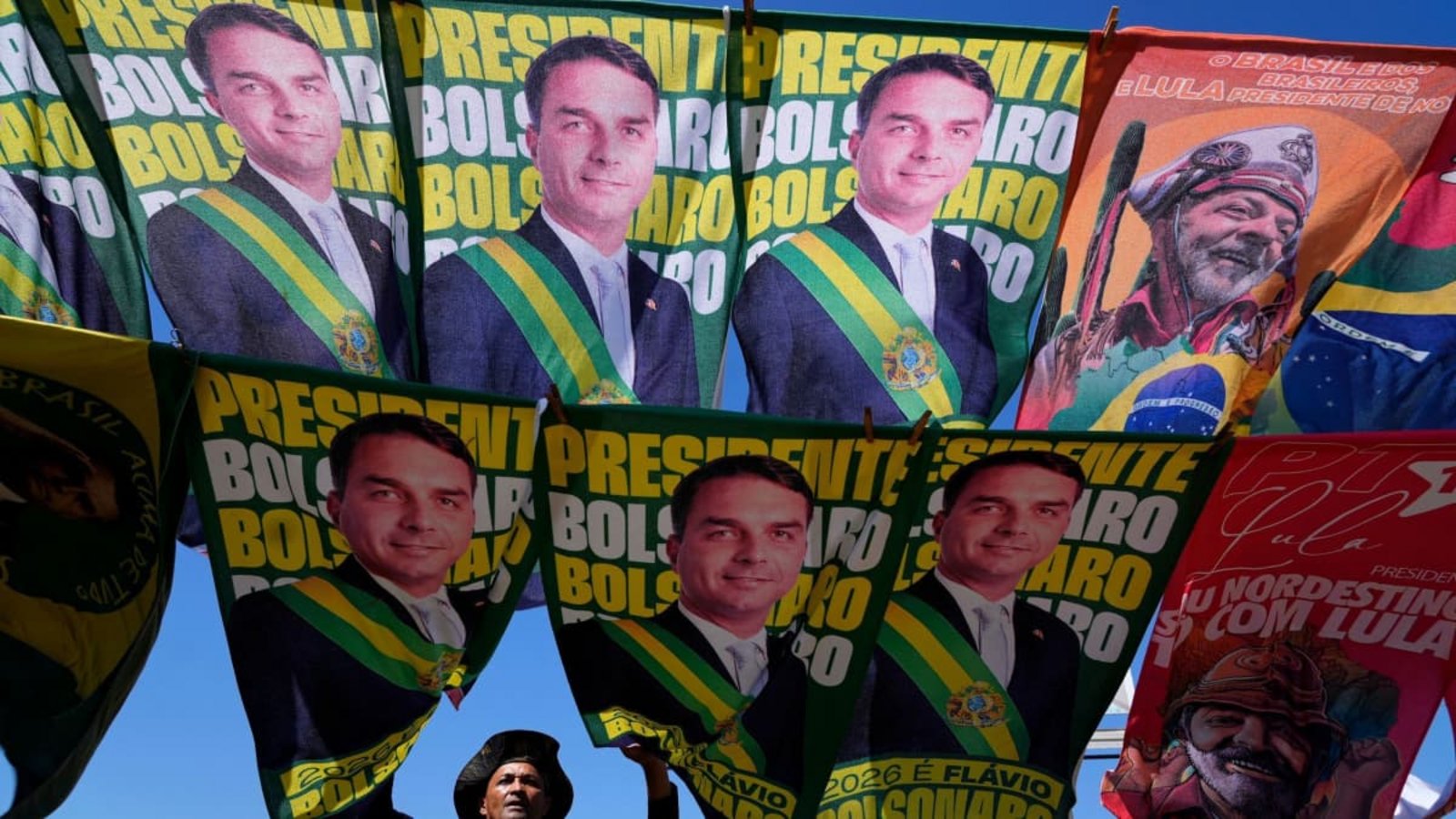 Ein Straßenhändler verkauft Wahlkampf-Fahnen der Präsidentschaftskandidaten Bolsonaro und des amtierenden Präsidenten Lula da Silva, der sich um eine Wiederwahl bewirbt. (zu dpa: «Verdacht auf ausländische Wahlkampfhilfe für Bolsonaro-Sohn»)Eraldo Peres/AP/dpa