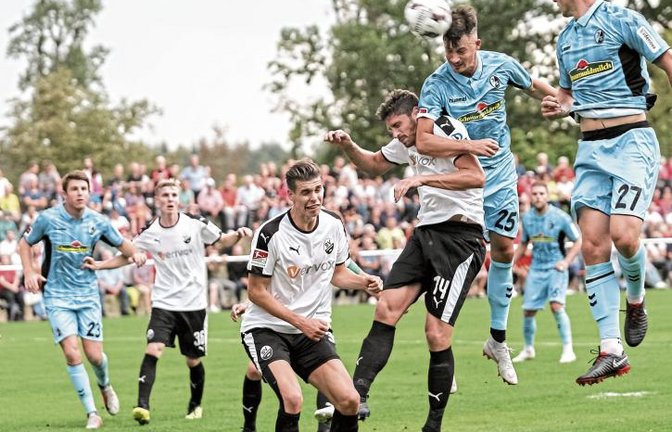 Freiburgs Robin Koch überspringt Sandhausens Tim Kister. Das Einweihungsspiel für den neuen Löchgauer Rasen zwischen dem Erst- und dem Zweitligisten war abwechslungsreich. Foto: Simecek