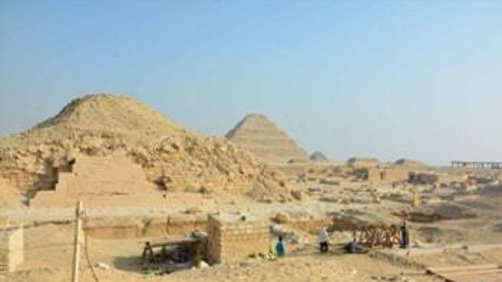 Das Grabungsfeld des Saqqara Saite Tombs Project befindet sich nahe der Unas-Pyramide (links im Bild). Sie ist die kleinste Königspyramide aus dem Alten Reich (2700 bis 2200 v. Chr.) und steht neben der Stufenpyramide des Djoser (hinten in der Bildmitte).Foto: © Saqqara Saite Tombs Project, Universität Tübingen. Fotograf: S. Beck Das Grabungsfeld des Saqqara Saite Tombs Project befindet sich nahe der Unas-Pyramide (links im Bild). Sie ist die kleinste Königspyramide aus dem Alten Reich (2700 bis 2200 v. Chr.) und steht neben der Stufenpyramide des Djoser (hinten in der Bildmitte).Foto: © Saqqara Saite Tombs Project, Universität Tübingen. Fotograf: S. Beck