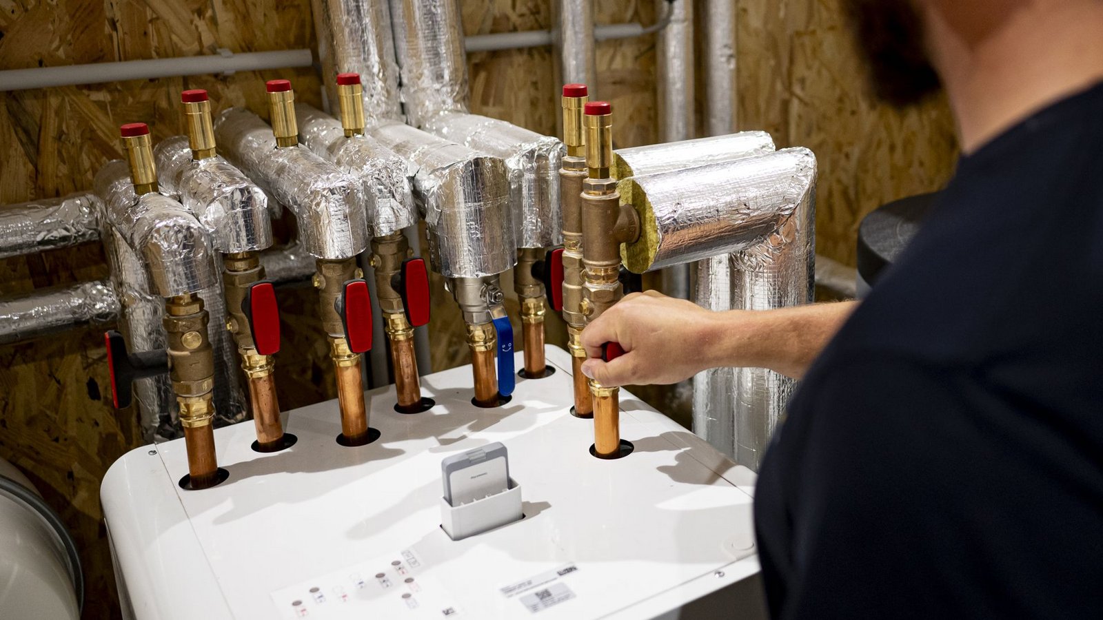 Ein Handwerker beim Installieren einer Wärmepumpe. Im Neubau setzt sich diese Heizungsform durch – im Bestand sind Hausbesitzer oft skeptisch.Foto: dpa/Fabian Sommer