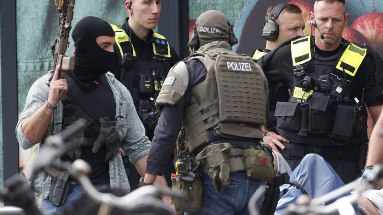 Einsatzkräfte stehen vor einem Supermarkt neben einer verletzten Person auf einer Trage. In dem Supermarkt im Süden Berlins hielt ein Mann seit dem späten Freitagabend eine Frau als Geisel. Die Geiselnahme wurde durch die Polizei beendet.Carsten Koall/dpa Einsatzkräfte stehen vor einem Supermarkt neben einer verletzten Person auf einer Trage. In dem Supermarkt im Süden Berlins hielt ein Mann seit dem späten Freitagabend eine Frau als Geisel. Die Geiselnahme wurde durch die Polizei beendet.Carsten Koall/dpa