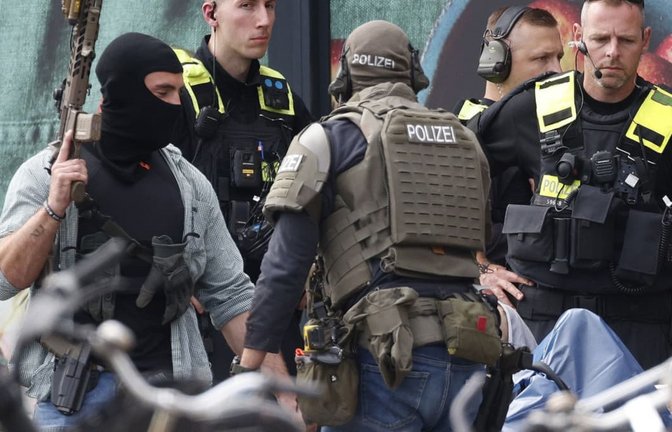 Einsatzkräfte stehen vor einem Supermarkt neben einer verletzten Person auf einer Trage. In dem Supermarkt im Süden Berlins hielt ein Mann seit dem späten Freitagabend eine Frau als Geisel. Die Geiselnahme wurde durch die Polizei beendet.<span class='image-autor'>Carsten Koall/dpa</span>