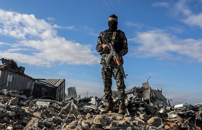 Ein Kämpfer der Al-Kassam-Brigaden, des militärischen Flügels der Hamas, steht in der Nähe von Ruinen Wache, während israelische Geiseln an Vertreter des Internationalen Komitees vom Roten Kreuz (IKRK) übergeben werden. (Archivbild)<span class='image-autor'>Foto: dpa/Abed Rahim Khatib</span>