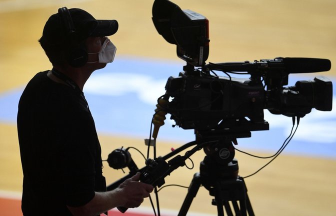 Ein Kameramann steht mit Mundschutz am Rand eines Basketballfeldes.<span class='image-autor'>Foto: Andreas Gebert/Reuters-Pool/dpa</span>