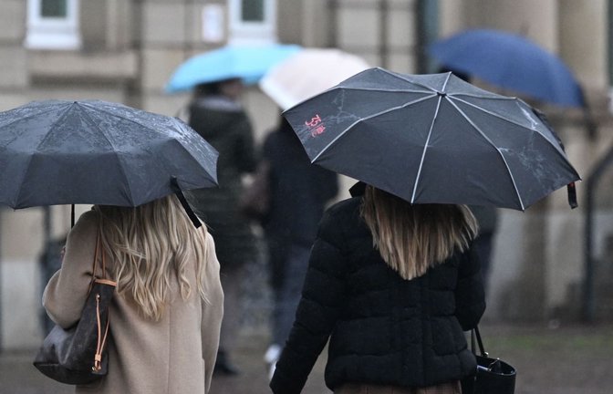 Passanten mit Regenschirmen laufen über den Schlossplatz. Der Deutsche Wetterdienst warnt vor Dauerregen: Bis Donnerstag könnten örtlich bis zu 100 Liter pro Quadratmeter fallen. (zu dpa: «Am Sonntag wird es im Südwesten regnerisch und kühl»)<span class='image-autor'>Bernd Weißbrod/dpa</span>