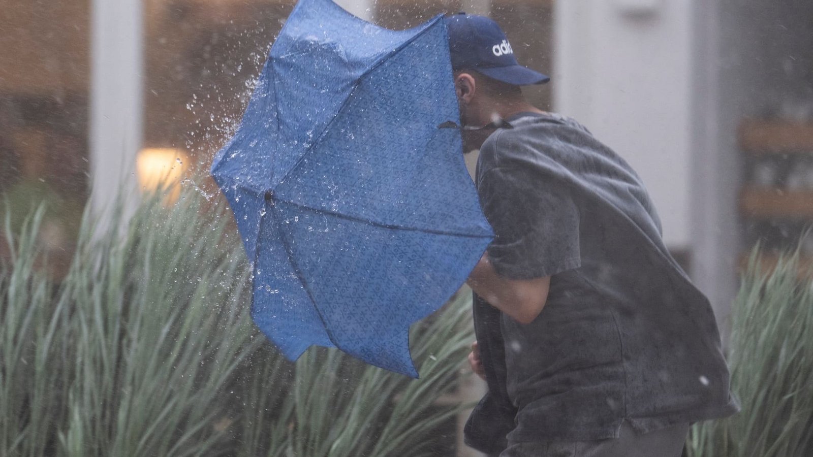 Ein Mann rennt in Stuttgart durch starken Regen und versucht, sich mit einem Regenschirm zu schützen. (zu dpa: «Regnerischer Tag: Wo sogar Gewitter und Sturmböen drohen»)Marijan Murat/dpa