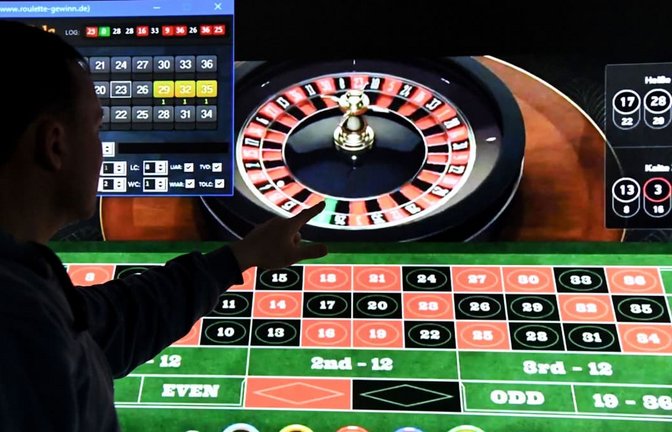 Ein Mann steht vor einem Bildschirm mit einer Seite für Online-Roulette. Um viel Geld auf Schwarz oder Rot zu setzen, muss man mittlerweile nicht mehr in ein Kasino oder eine Spielbank gehen.<span class='image-autor'>Carsten Rehder/dpa</span>