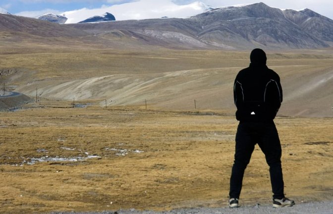 Das geht. Aber nur weil es keine Autobahn ist: Ein Tourist pinkelt am Straßenrand des Tanggula-Passes im Hochland von Tibet<span class='image-autor'>Imago/biky</span>