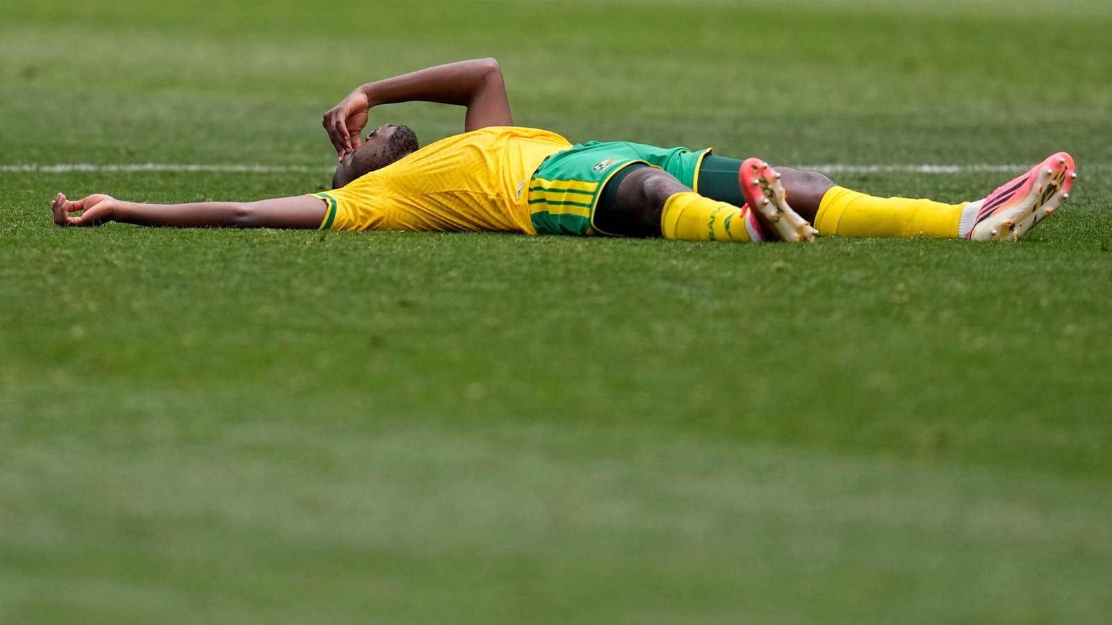 Der Südafrikaner Aubrey Modiba liegt nach dem Spiel auf dem RasenFoto: Gregory Bull/AP/dpa Der Südafrikaner Aubrey Modiba liegt nach dem Spiel auf dem RasenFoto: Gregory Bull/AP/dpa