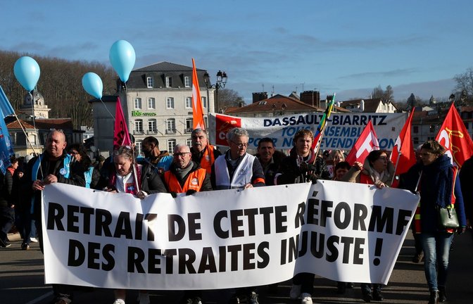 Demonstranten halten ein Transparent mit der Aufschrift "Rücknahme der ungerechten Rentenreform" während eines Protestmarsches in Bayonne.<span class='image-autor'>Foto: Robert Edme/AP/dpa</span>