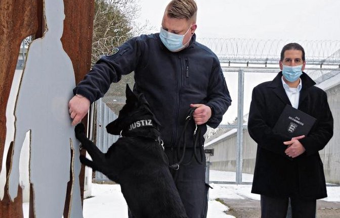 Spürhund Emily wird de Vollzugsbediensteten künftig unterstützen, wenn sie nach unerlaubten Mobiltelefonen suchen. Vorgestellt wurde das Tier am Montag von Florian Weiner und Frank Jansen (von links). Foto: Friedrich