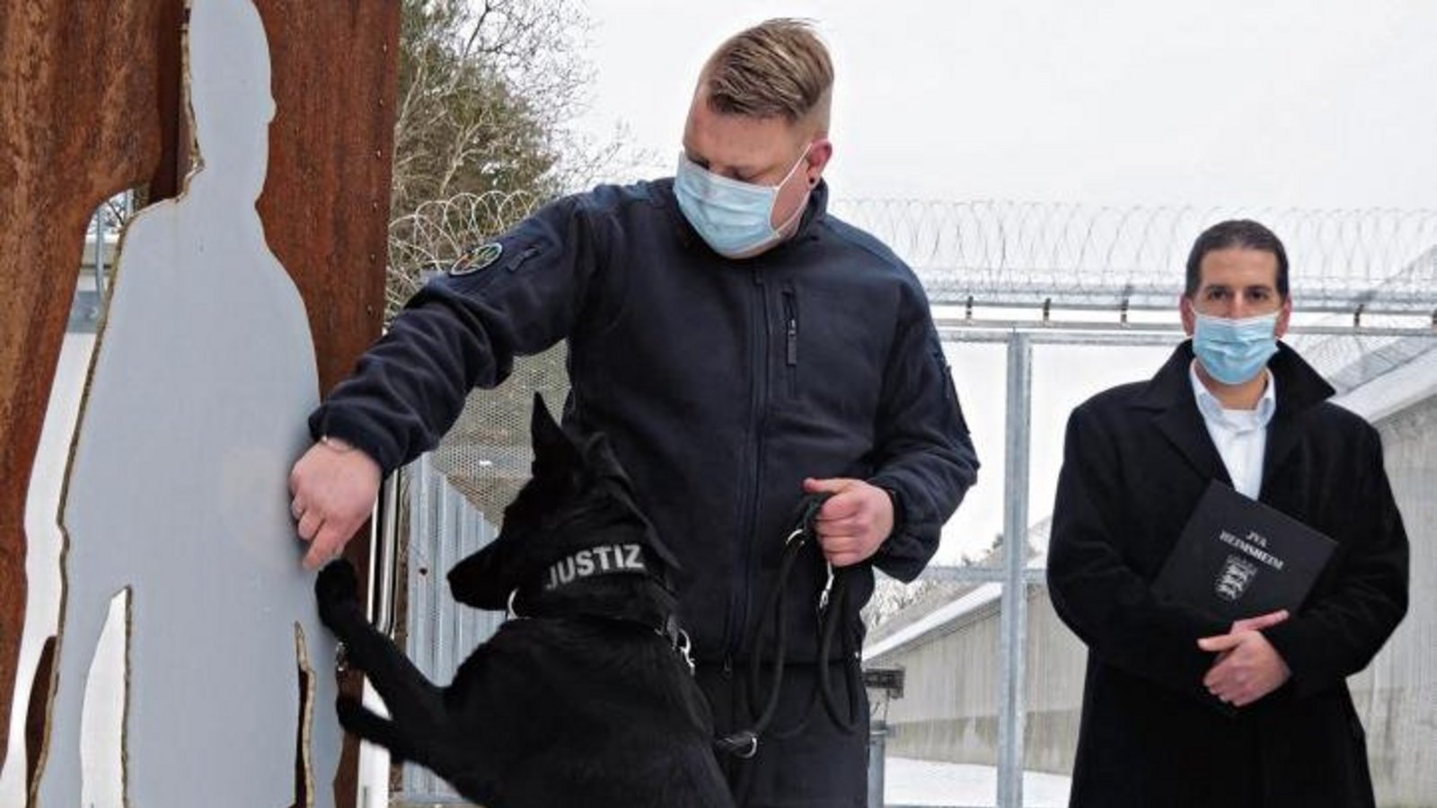 Spürhund Emily wird de Vollzugsbediensteten künftig unterstützen, wenn sie nach unerlaubten Mobiltelefonen suchen. Vorgestellt wurde das Tier am Montag von Florian Weiner und Frank Jansen (von links). Foto: Friedrich