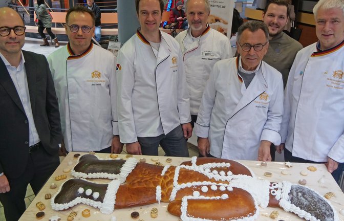 In den Reihen seiner Kollegen verleiht Innungsobermeister Martin Reinhardt (rechts) seinem Vorgänger Manfred Förster (Dritter von rechts) den „großen Dambedei“,