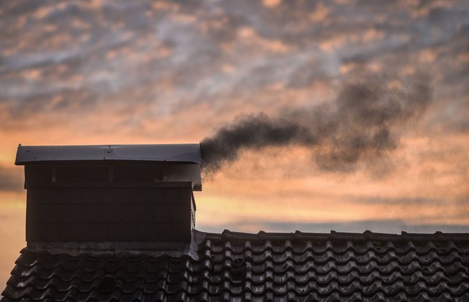 Schwarzer Rauch dringt im Winter aus dem  Schornstein eines Wohnhauses.<span class='image-autor'>Foto: Imago/Markus van Offern</span>