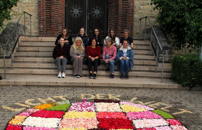 Frühaufsteherinnen: Das Team, das vor der St. Antonius-Kirche den Blumenteppich legt.    Foto: Kauer