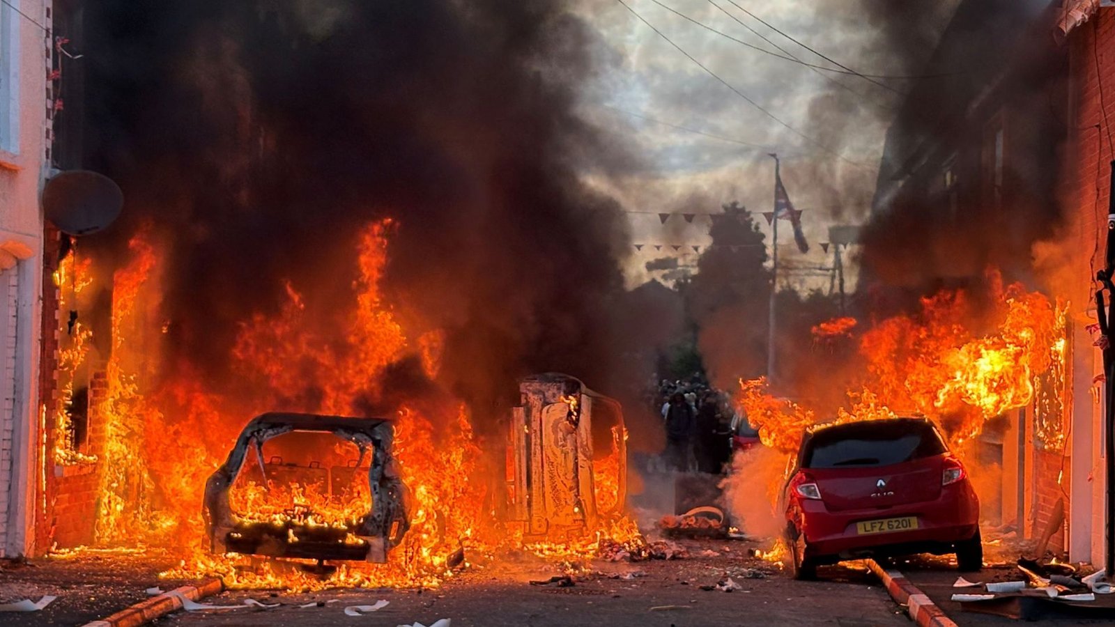 Demonstranten setzten Autos und auch Gebäude in Brand.Foto: Pa/PA Wire/dpa/Pa