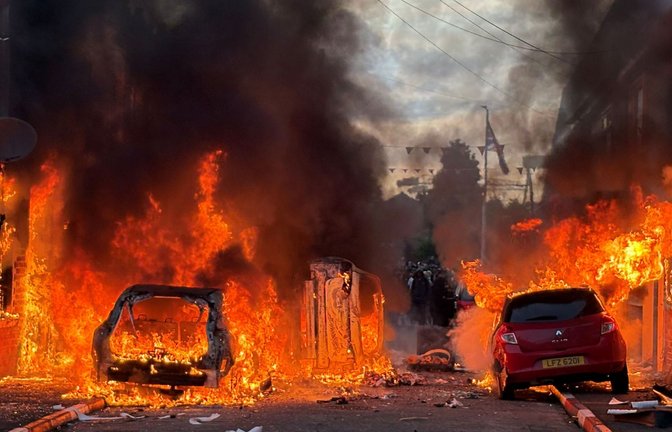 Demonstranten setzten Autos und auch Gebäude in Brand.<span class='image-autor'>Foto: Pa/PA Wire/dpa/Pa</span>