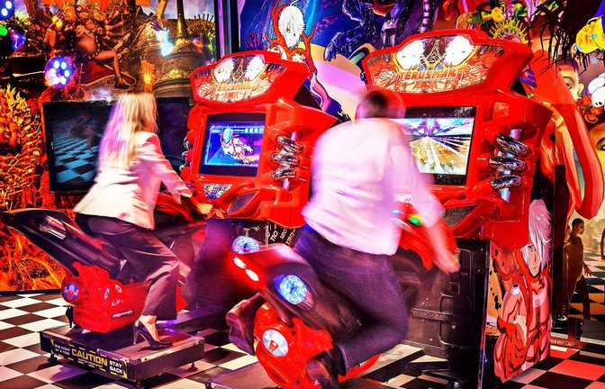 Auch Erwachsene spielen gern. Auf den Motorrädern sind sie im Vorteil, weil  die Maschinen mit dem Körpergewicht zur Seite geneigt werden müssen, um virtuellen den Hindernissen auszuweichen.<span class='image-autor'>Foto: Zeppelin Museum
/Markus Tretter</span>