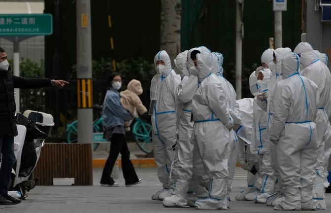 Arbeiter in Schutzkleidung versammeln sich in Peking zu ihrem Dienst. Die Behörden lockerten die Anti-Coronavirus-Bestimmungen in einzelnen Gebieten, bekräftigten aber Chinas strenge "Null-COVID"-Strategie.<span class='image-autor'>Foto: Andy Wong/AP/dpa</span>