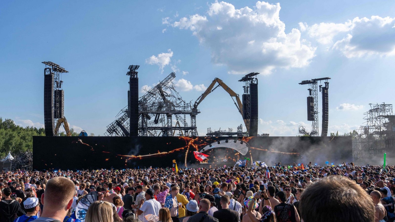 Vor der Kulisse der niedergebrannten Hauptbühne in Boom feiern die Festivalbesucher.Foto: AFP/MARIUS BURGELMAN Vor der Kulisse der niedergebrannten Hauptbühne in Boom feiern die Festivalbesucher.Foto: AFP/MARIUS BURGELMAN