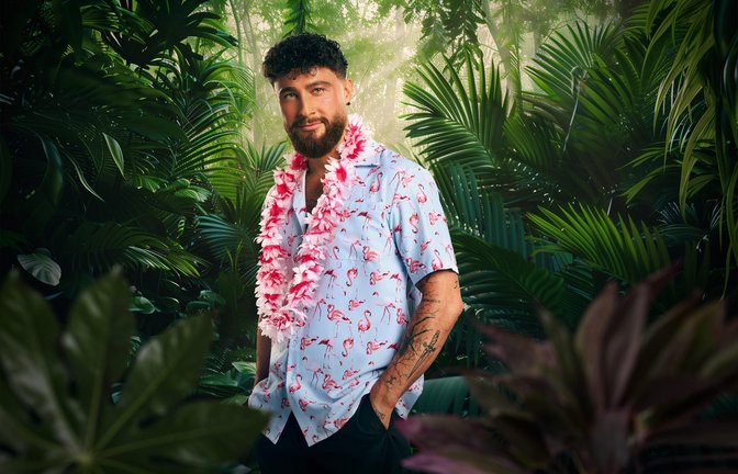 Umut Tekin nimmt am „Dschungelcamp“ 2026 teil.<span class='image-autor'>Foto: RTL / Hintergrund KI-generiert</span>