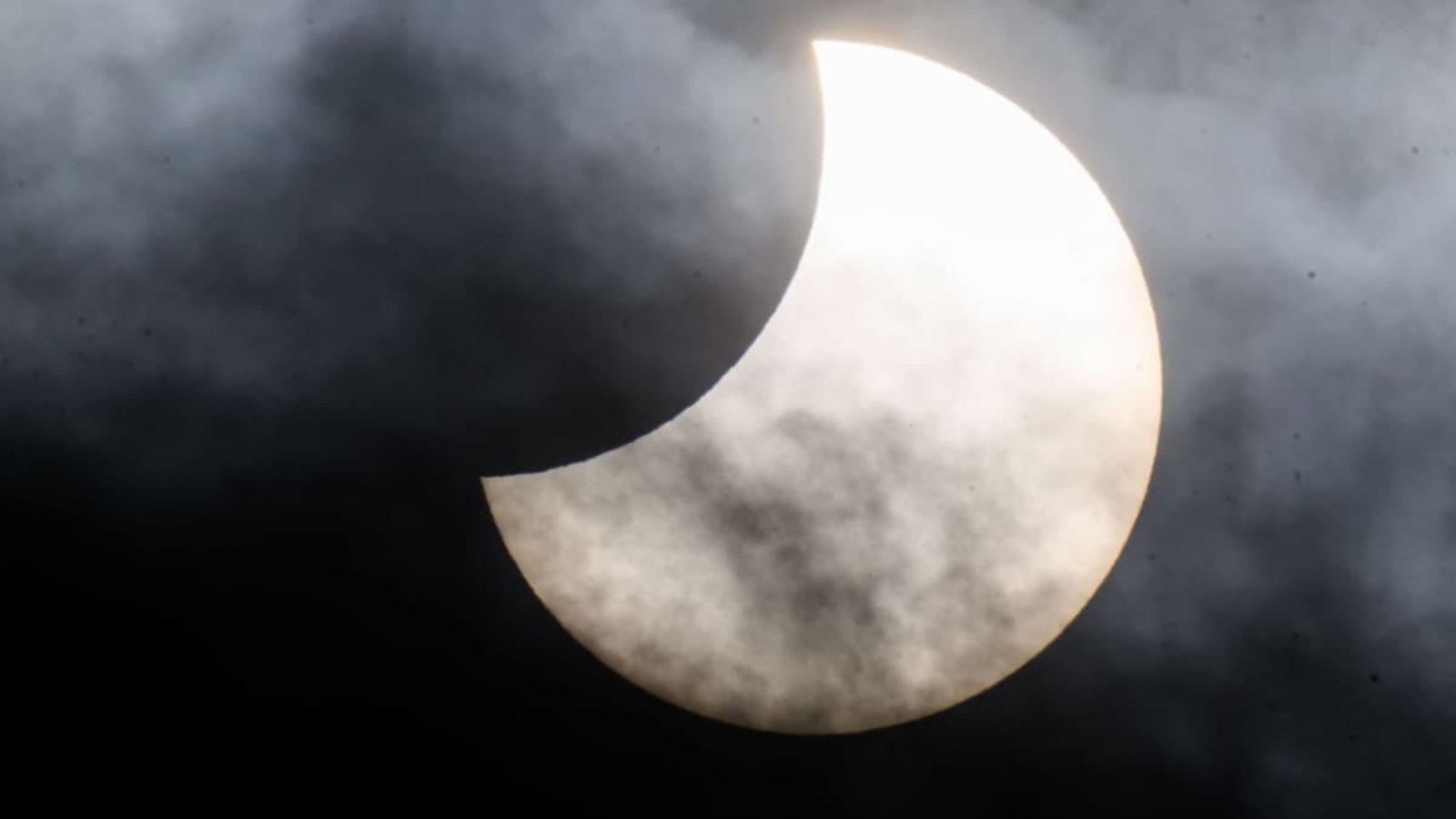 Eine partielle Sonnenfinsternis ist zwischen Wolken am Himmel zu sehen. (Aufnahme stammt aus Niedersachsen).Julian Stratenschulte/dpa Eine partielle Sonnenfinsternis ist zwischen Wolken am Himmel zu sehen. (Aufnahme stammt aus Niedersachsen).Julian Stratenschulte/dpa