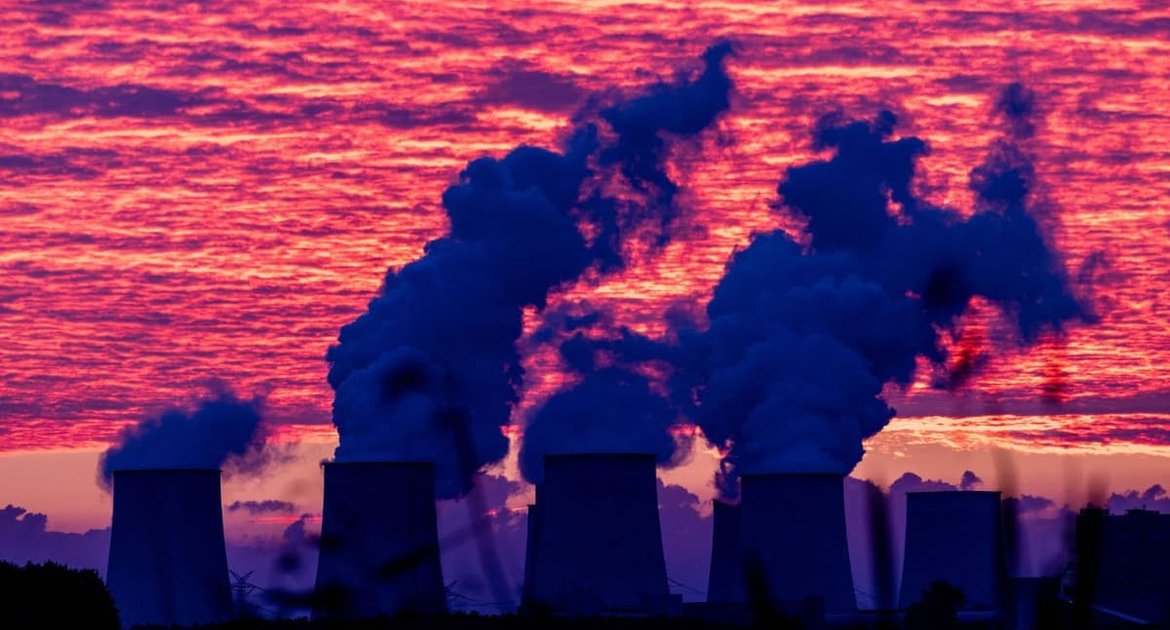 Der bevorstehende Sonnenaufgang färbt den Himmel über den Kühltürmen des Kraftwerkes Jänschwalde rot. Nach der Sabotage am Stromnetz in Südbrandenburg führt die Polizei die großräumige Durchsuchung am Ereignisort heute weiter.