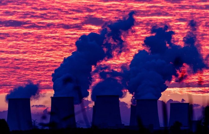 Der bevorstehende Sonnenaufgang färbt den Himmel über den Kühltürmen des Kraftwerkes Jänschwalde rot. Nach der Sabotage am Stromnetz in Südbrandenburg führt die Polizei die großräumige Durchsuchung am Ereignisort heute weiter.<span class='image-autor'>Frank Hammerschmidt/dpa</span>