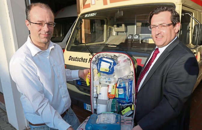 Tobias Mäule (links) und Klaus Reitze zeigen einen Notfallrucksack, mit dem die Helfer vor Ort des DRK künftig auch in Vaihingen und den Stadtteilen zu Notfallpatienten ausrücken sollen. Die aufwendige Ausstattung einschließlich Defibrillator (vorne) ermöglicht effektive Hilfe. Foto: Küppers