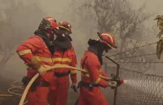 Spanische Feuerwehrmänner mit Atemschutzmasken bekämpfen einen Waldbrand bei Nava del Rey nahe Madrid.<span class='image-autor'>Imago/Anadolu Agency</span>