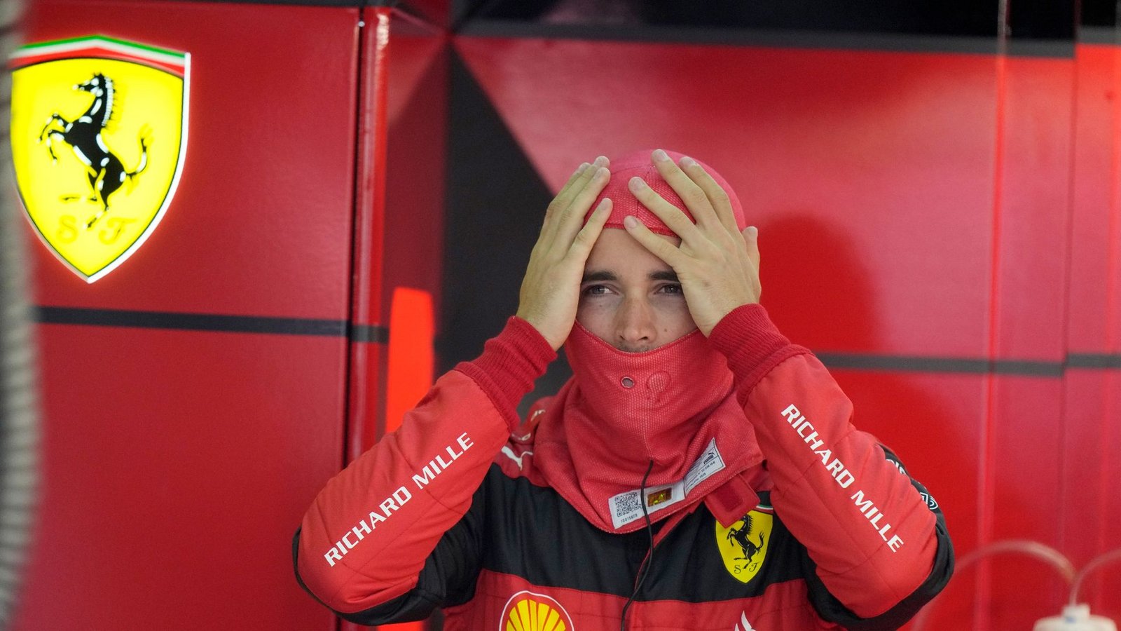 Ferrari-Pilot Charles Leclerc setzt vor Beginn des Freien Trainings seine Sturmhaube auf.Foto: Luca Bruno/AP/dpa