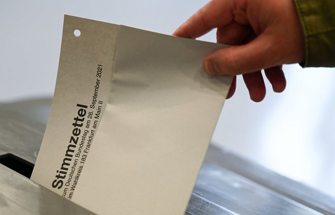 Ein Mann steckt den Stimmzettel für die Bundestagswahl 2021 ein.<span class='image-autor'>Foto: dpa/Arne Dedert</span>
