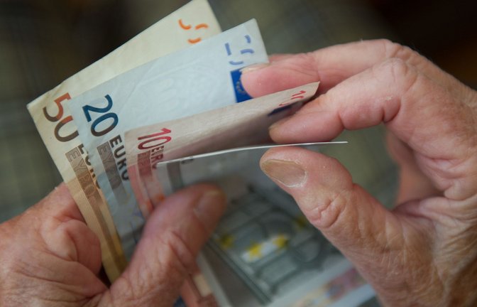 Eine ältere Frau zählt Geld. (Archivbild)<span class='image-autor'>Foto: Marijan Murat/dpa</span>